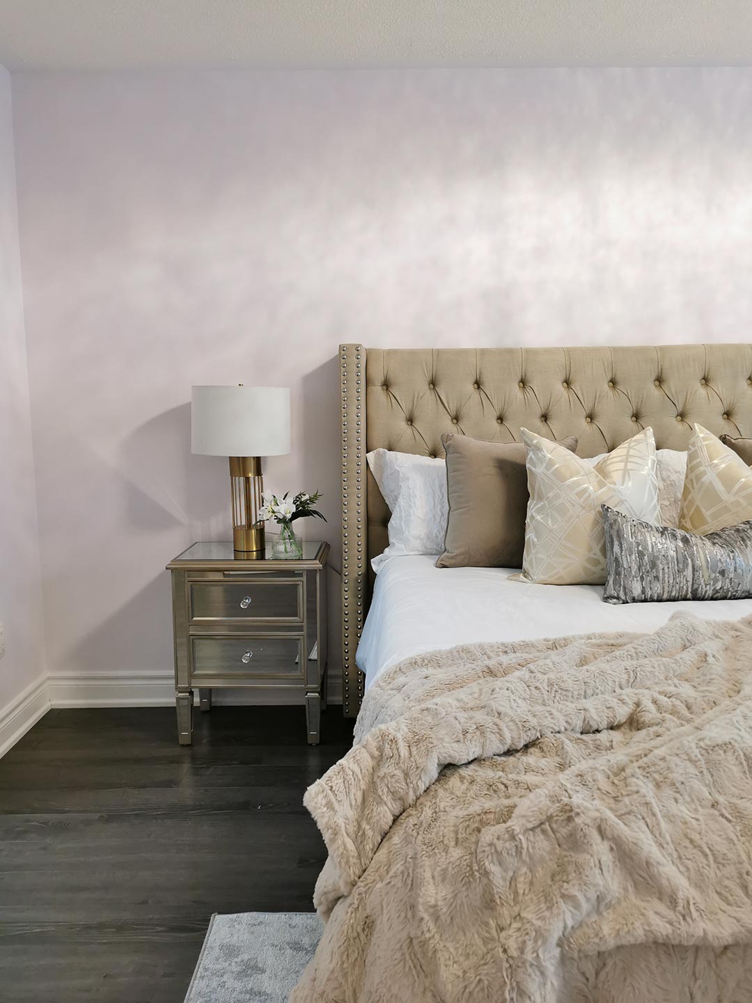 Bedroom styled by an interior designer showing half the bed and a side table