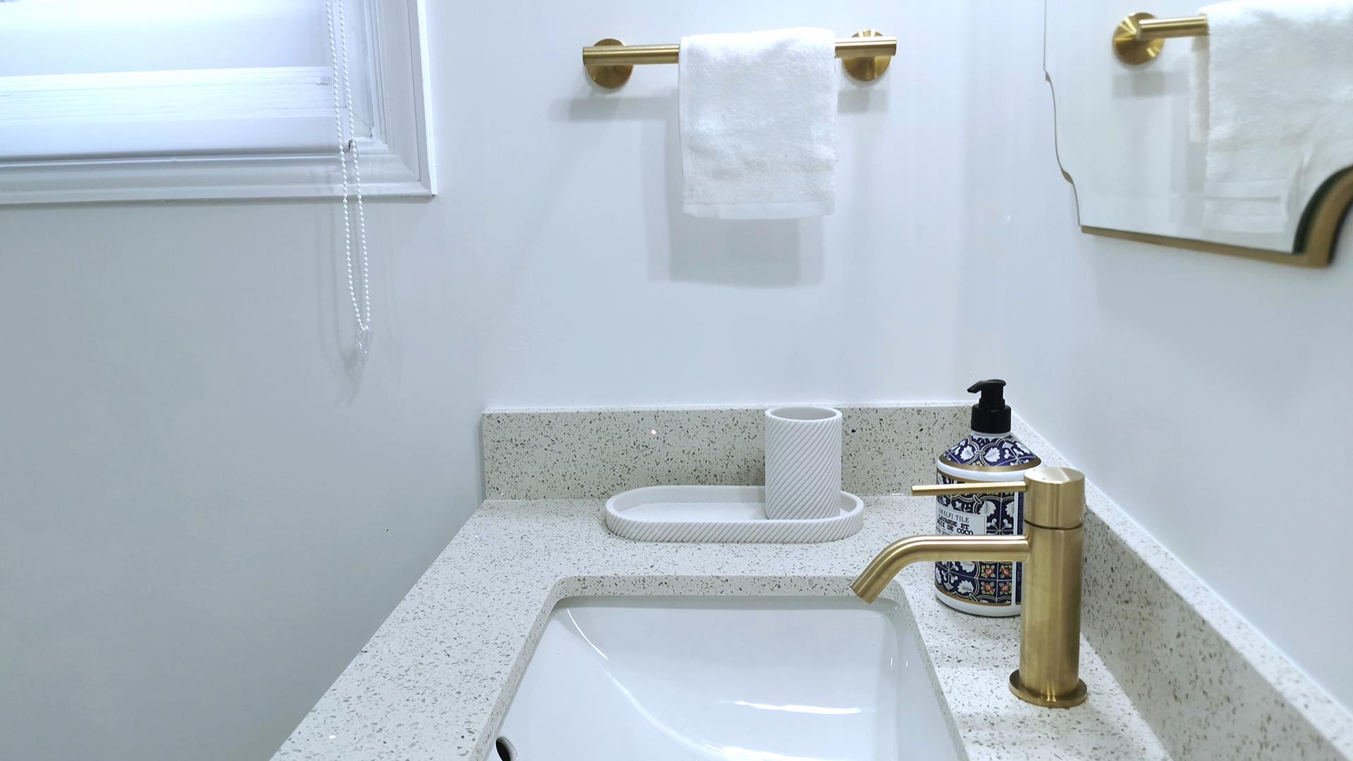 Master Bathroom Sink with gold faucet and towel holder