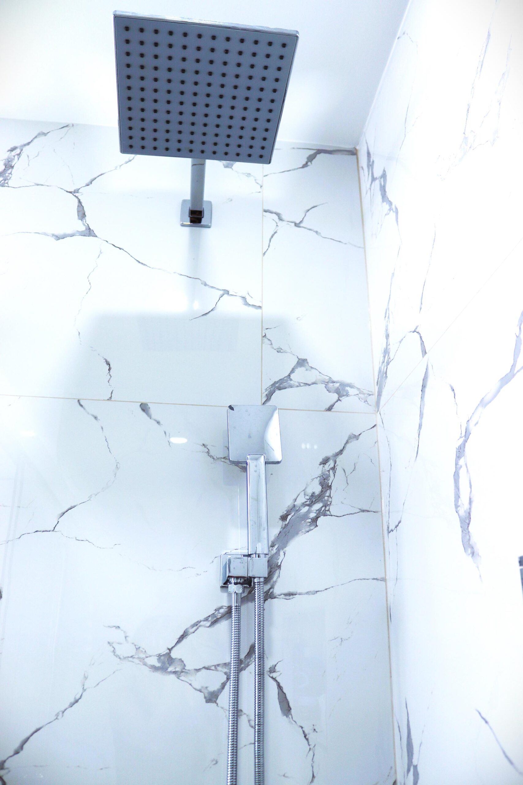 Bathroom Renovation showing marble tile in shower with rain showerhead